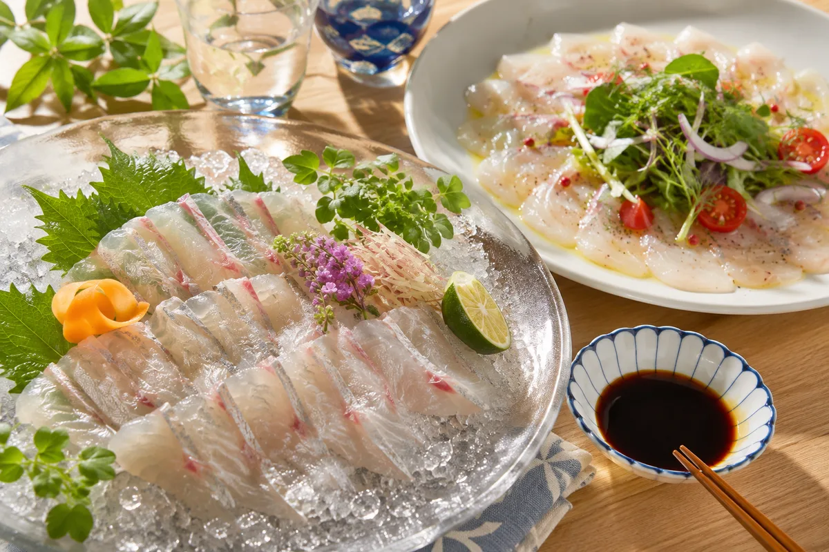 釣りたてスズキの洗いとカルパッチョが並ぶ食卓。透明感のある白身と氷の輝きが美しい料理写真